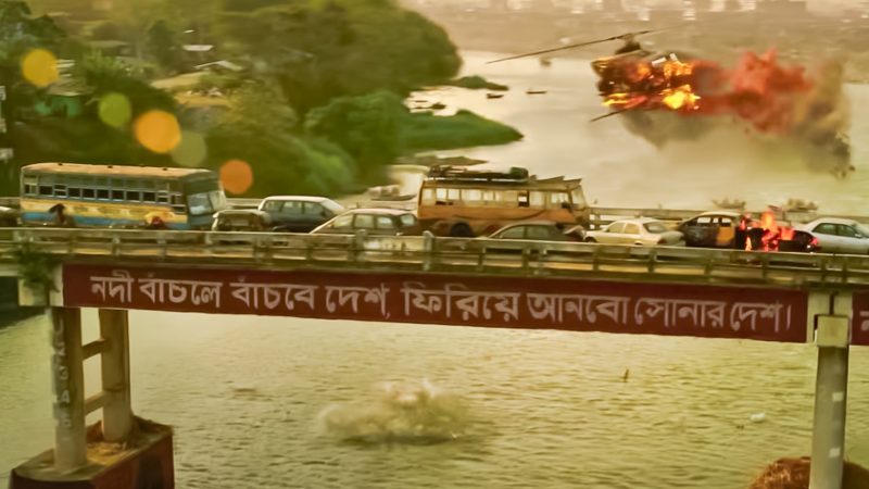 Extrait du film "Tyler Rake". Un pont traversant une rivière est embouteillé. Un avion en feu survole la scène.